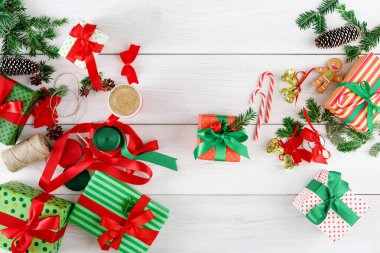 Hediyeler açık ahşap bir masaya dizilir. Hediyeler çeşitli ambalaj kağıtlarına sarılır ve kurdelelerle bağlanır. Dekorasyonlar arasında çam kozalakları, baston şekerler ve yeşil yapraklar yer alıyor..