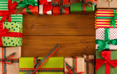 Renkli hediye kutuları ahşap bir masanın üzerine düzgünce dizilir. Hediyeler çeşitli desenlere ve renklere bürünmüş, şenlik için hazırlar..