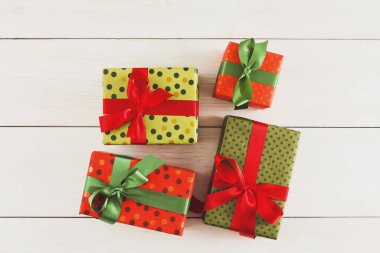 Düz bir tahta yüzeyde dört hediye kutusu düzenlenir. Her kutunun farklı renkleri ve desenleri var. Kutular parlak kurdelelerle bağlanmış..