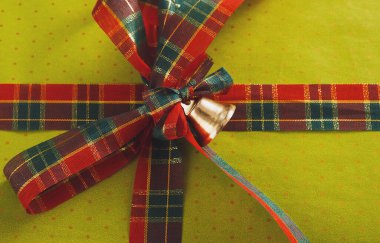 Bu kolaj düzgün bir şekilde düzenlenmiş çeşitli hediye paketleme malzemelerini gösterir. Parlak renkler ve desenler, kurdeleler ve bir çan ile birlikte kutlamaya hazırdır..