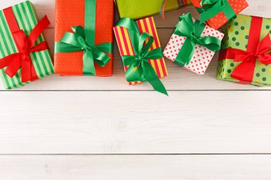 Bir dizi hediye ahşap bir yüzeye düzgünce dizilir. Her hediye farklı renklerde kağıda sarılır ve yeşil kurdelelerle bağlanır. Hediyeler boyut ve tasarım olarak farklıdır..