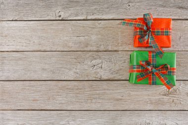 Kırsal ahşap bir masada kırmızı ve yeşile sarılı iki hediye düzenlenir. Hediyelerin kurdeleleri var ve bayram ya da kutlama için hazırlar..