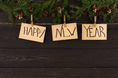 Kartlar ahşap bir yüzeyde mandallarla asılıdır. Her kartta 