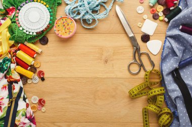 Bir set dikiş ve el işi malzemesi ahşap bir masa üzerinde düzenlenir. Renkli iplikler, makas, mezura, düğmeler ve diğer malzemeler sergilenmektedir. Çeşitli doku ve ögeler mevcuttur.