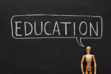 Tahtaya eğitici sözcükler ve cümleler yazılır. Tahta bir figür yakınlarda duruyor, öğrenme temasını vurguluyor. Bu ayar çeşitli öğretim yöntemlerini sunar.