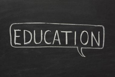 Siyah bir karatahta beyaz tebeşirle yazılmış eğitim sözcüğünü içerir. Ayarlar bir sınıf ya da öğrenme ortamı olduğunu gösteriyor. Odaklanma konsepti öğrenme ve öğretme.