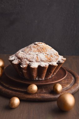 Ahşap masada kek ve altın yumurta ile Paskalya arka plan