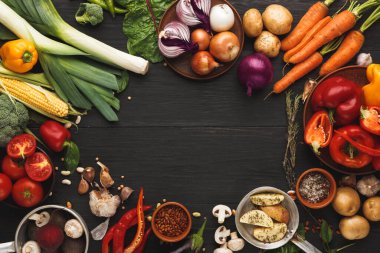 Taze sebzeler ahşap bir masanın üzerindeki mozaikte düzenlenir. Sette biber, havuç, domates, soğan ve diğer ürünler yer alıyor. Bu sağlıklı yiyecek seçeneklerinin bir göstergesi..