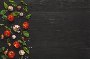 Koyu ahşap bir yüzeye kırmızı domates, sarımsak ve yeşil fesleğen yaprakları dizilir. Ögeler, yemek hazırlama veya tarif tasarımı için mozaik bir görünüm oluşturmak üzere dikkatlice yerleştirilmiştir..