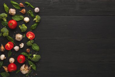 Koyu ahşap bir yüzeye taze sebze koleksiyonu yerleştirilir. Domates, sarımsak, ıspanak ve brokoli yaratıcı bir düzende düzenlenmiştir..