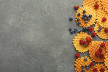 Düz bir yüzeye farklı waffle türleri yerleştirilir. Ahududu ve yaban mersini waffle 'ların arasına dağılmış. Ayarlar basit ve yiyeceğe odaklı..