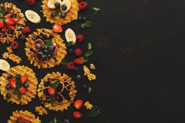 Çilek, yabanmersini ve muz gibi taze meyvelerle mozaik tarzda çeşitli waffle 'lar düzenlenir. Bazı waffle 'lar çikolata ve malzemelerle renklendirilir..