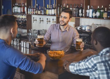 Yakışıklı barmen iki adam hizmet, onlara bira ile gözlük veren