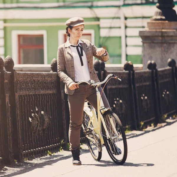 Молодая женщина на винтажном велосипеде британского стиля — стоковое фото
