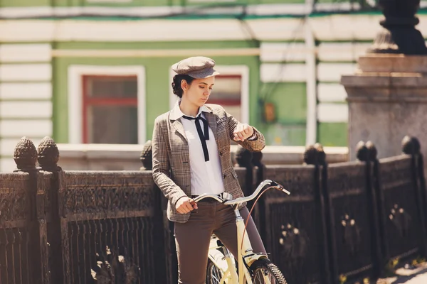 Молодая женщина на винтажном велосипеде британского стиля — стоковое фото