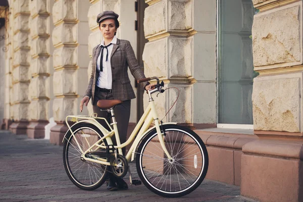 Young woman at vintage bicycle british style — Stok fotoğraf