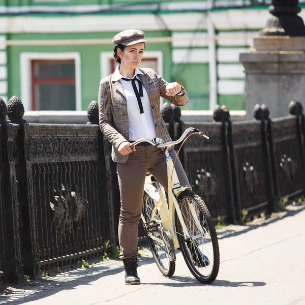 Mujer joven en bicicleta vintage estilo británico — Foto de Stock