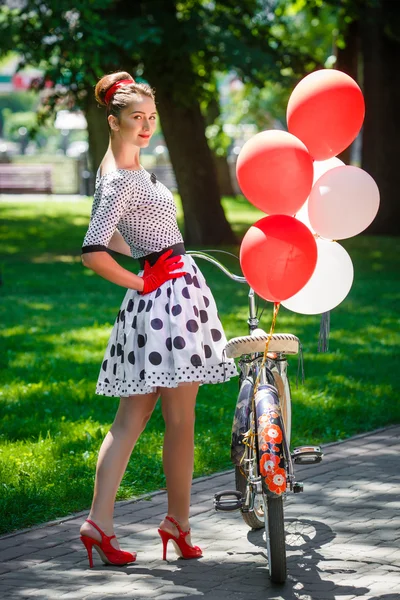 Молодая женщина ретро-пин-ап в стиле с велосипедом — стоковое фото