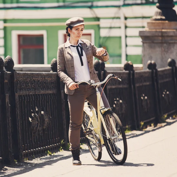 Jovem mulher no estilo britânico de bicicleta vintage — Fotografia de Stock