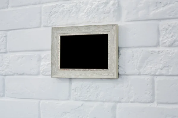 Пустая рамка на стене из белого кирпича — стоковое фото