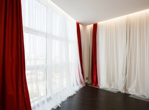 Living room window with red curtains Rechtenvrije Stockafbeeldingen