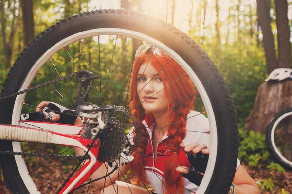 Joven ciclista deportista reparando su bicicleta mtb en el bosque — Foto de Stock