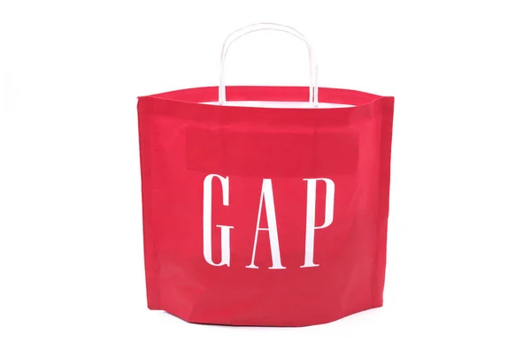 Gap marka amblemi olan bir alışveriş torbası, kırmızı, beyaz arka planda izole edilmiş. Gap giysileri, kırmızı kağıt torbası..