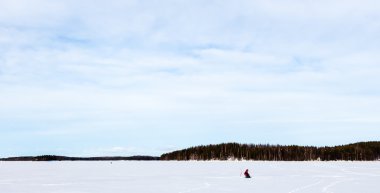 Kış göl kenarında balıkçı
