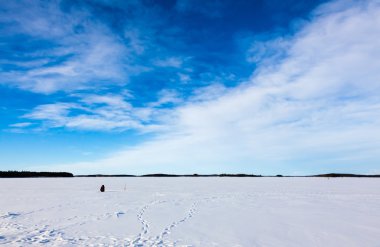 Kış göl kenarında balıkçı