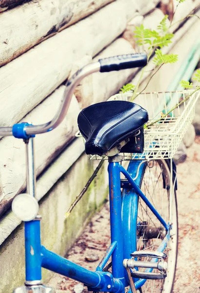Eski mavi Bisiklet ayakta ahşap duvarının yakınında