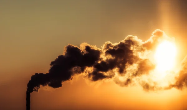 El humo de la chimenea en la puesta del sol —  Fotos de Stock