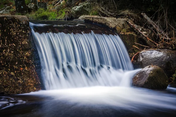 Waterfall in blurred motion with rocks in nature