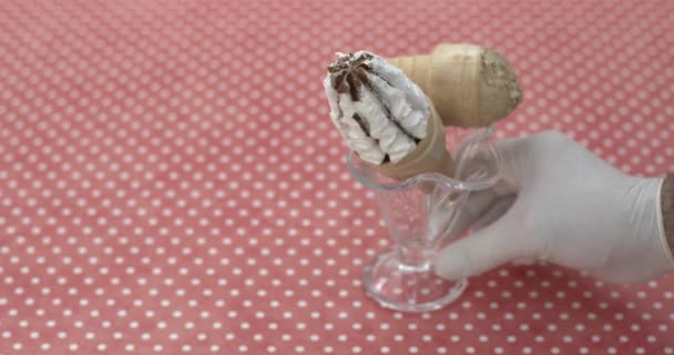 ruka v rukavici uvedení skleněná mísa se dvěma porcemi různé zmrzliny