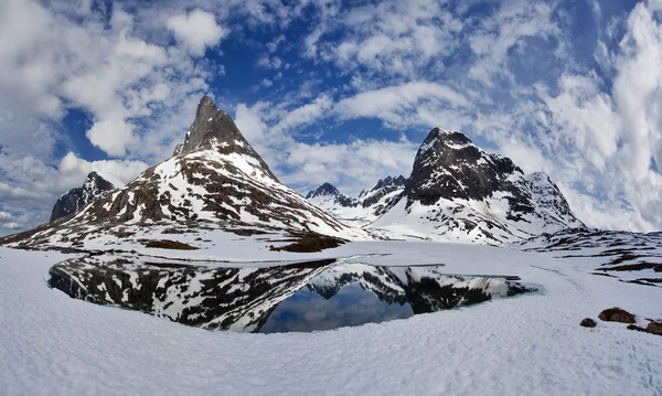 Acantilados cubiertos de nieve, reflejándose en el lago — Foto de Stock