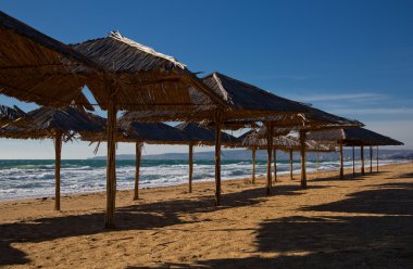 Beach umbrellas at the end of the season the sea
