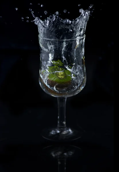 Siyah arka planda su sıçrama Kiwi