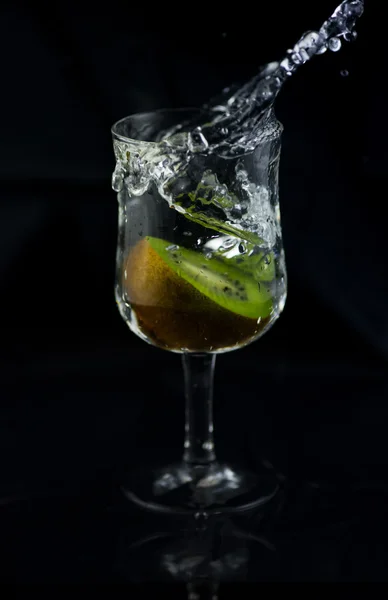 Siyah arka planda su sıçrama Kiwi