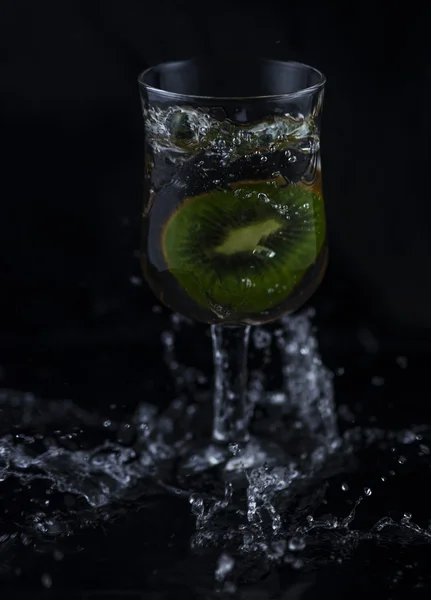 Siyah arka planda su sıçrama Kiwi