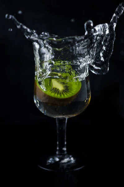 Siyah arka planda su sıçrama Kiwi