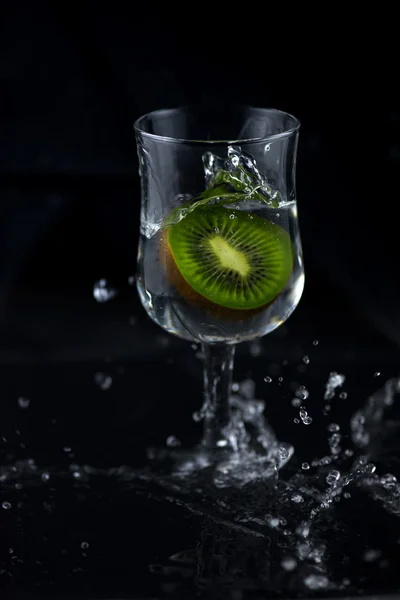 Siyah arka planda su sıçrama Kiwi