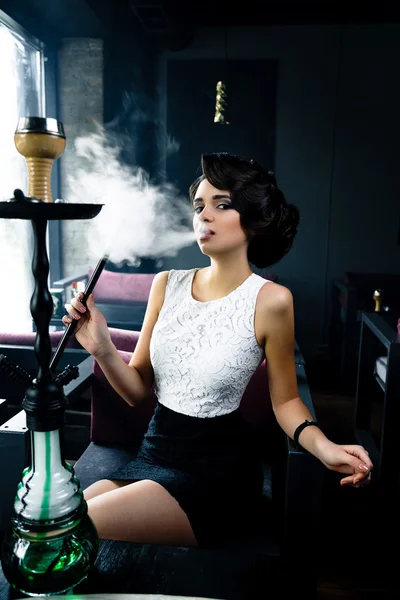 Женщина курит кальян в кафе — стоковое фото