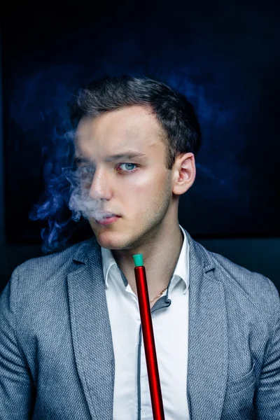 Man in blue suit smoking hookah — Stock Photo, Image