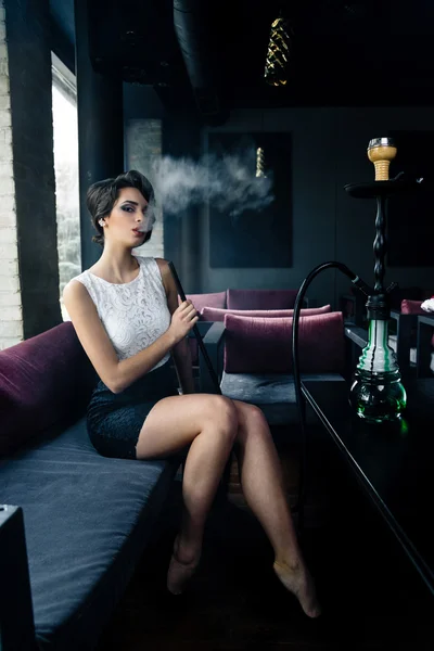 Woman smokes a hookah in cafe — Stock Photo, Image
