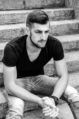 Duvara oturan yakışıklı adam