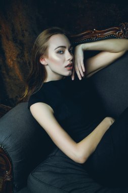 Sandalyede siyah elbiseli kadın