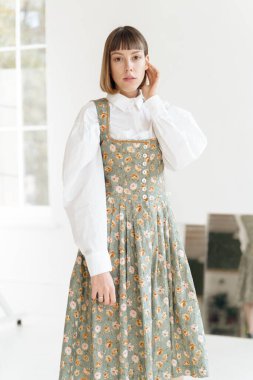 Stüdyoda poz veren eski moda elbiseli muhteşem genç kadın.