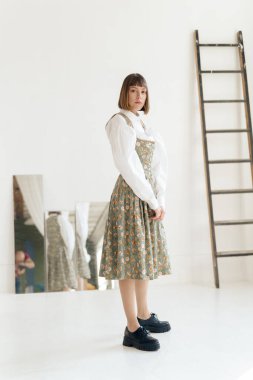 Stüdyoda poz veren eski moda elbiseli muhteşem genç kadın.