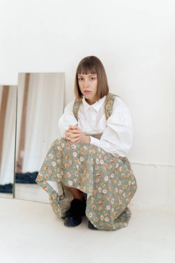 Stüdyoda poz veren eski moda elbiseli muhteşem genç kadın.