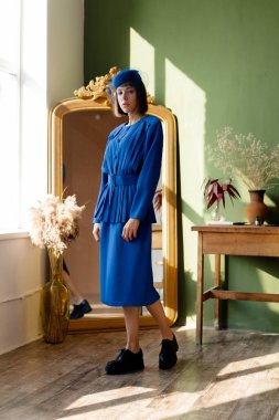 Geçmişe dönük mavi elbiseli güzel bir kadın.