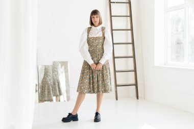 Stüdyoda poz veren eski moda elbiseli muhteşem genç kadın.